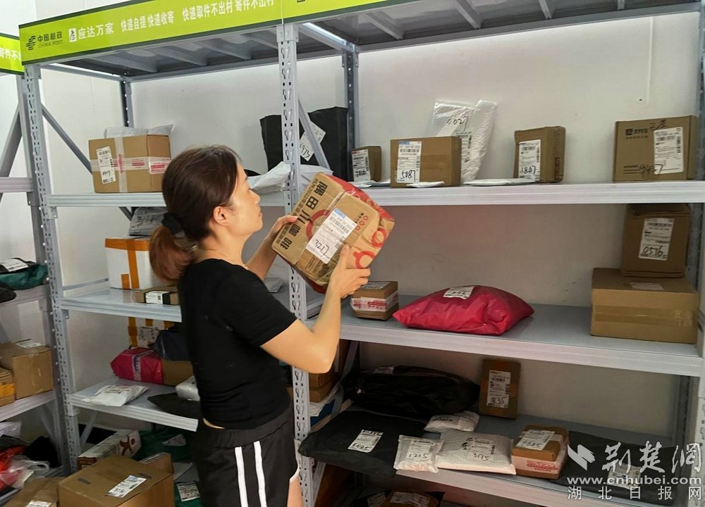 在城北街道西十村寄遞物流綜合便民服務(wù)站，站點負(fù)責(zé)人正在對快遞包裹進行分類擺放  攝 余新怡攝.jpg